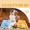 A dog is lying on a yellow mat with blue and green fabric pieces for sniffing training and slow feeding.