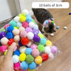 Klare Tasche gefüllt mit zehn 3cm Plüschspielzeugen in verschiedenen Farben und Texturen, neben einer Katze.