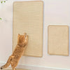 A tabby cat is scratching a woven natural fiber board mounted on a wall, next to another similar scratcher.