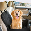 Un golden retriever sentado cómodamente en una funda para asiento de coche negra, mostrando el diseño de la cremallera.