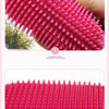 Close-up view of a bright pink rubber pet grooming brush with numerous rounded teeth.