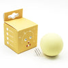 A yellow cardboard box for an interactive cat sounding toy with catnip, next to the spherical toy.