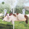 A fluffy white and brown cat is relaxing on a suction cup hammock designed for windowsills or glass.