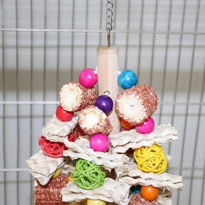 Buntes Holzpapagei-Kauspielzeug mit verschiedenen strukturierten und farbigen Teilen auf einem Ständer.