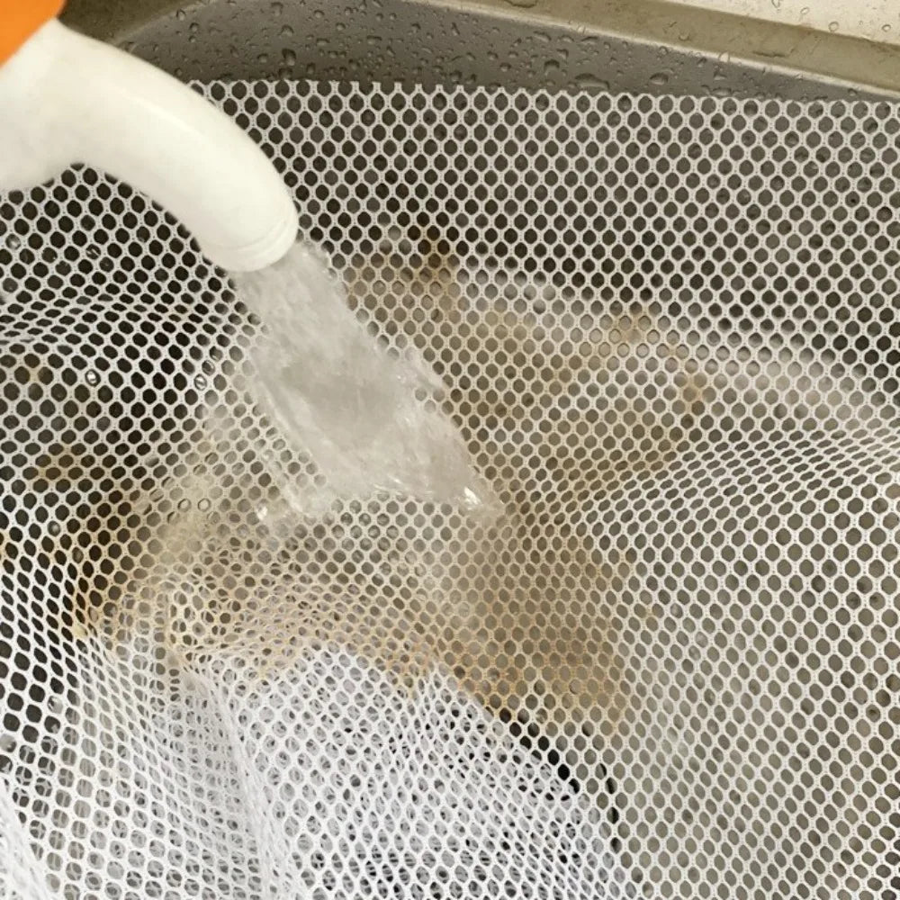 A white liquid is being poured into a mesh safety net used for balcony or stairs.
