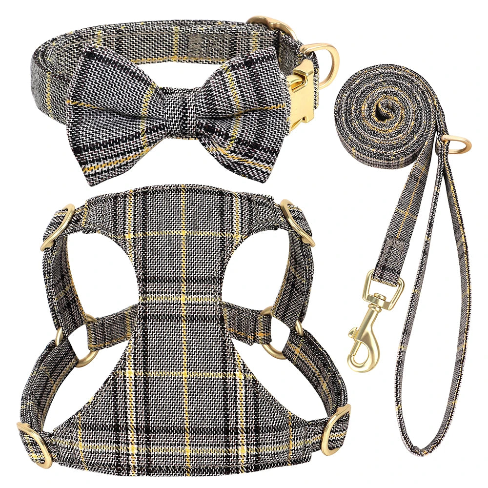 A plaid dog collar, harness, and leash set featuring a bowtie, in black and gold tones.