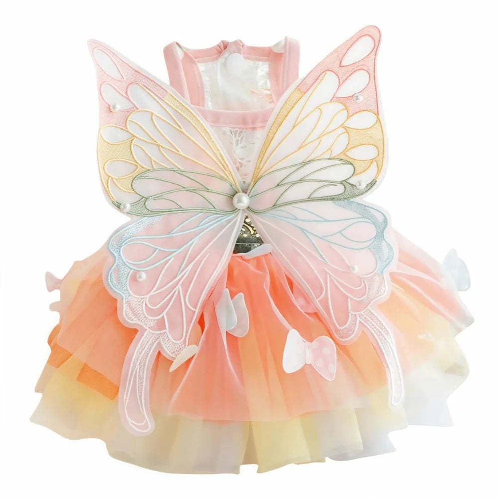 A pink rainbow butterfly pet dress for cats and dogs with sheer fabric wings and ruffled skirt.