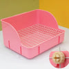 Una caja de arena rejilla rosa desmontable para pequeños mamíferos, mostrada sobre una superficie blanca.