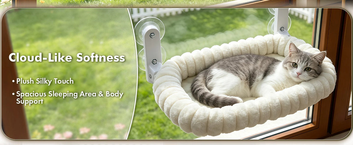 A domestic cat is relaxing in a fluffy, beige hammock-style perch suspended by suction cups near a window.