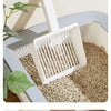 A white extra-large cat litter scoop with a hanging hook is shown scooping dry cat litter in a light blue plastic container.