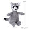 Juguete de peluche rayado en gris y negro que parece un mapache o oso, usado como juguete para masticar colmillos.