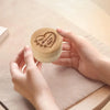 A hand holds a natural wooden keepsake box engraved with the words You love your pets and my heart.