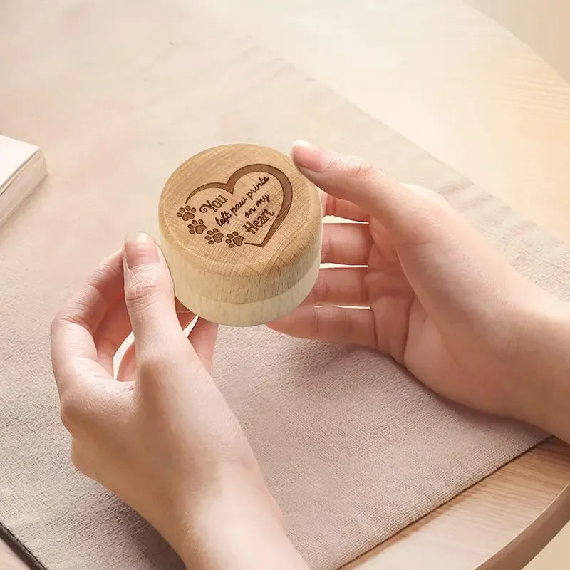 A hand holds a natural wooden keepsake box engraved with the words You love your pets and my heart.