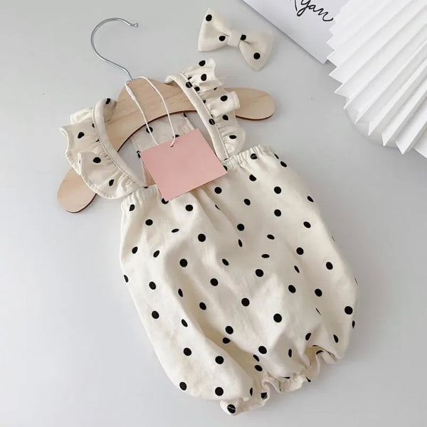 A cream-colored pet dress for a small dog featuring black polka dots and ruffled details.