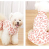 A fluffy white dog wearing a leopard print princess dress.