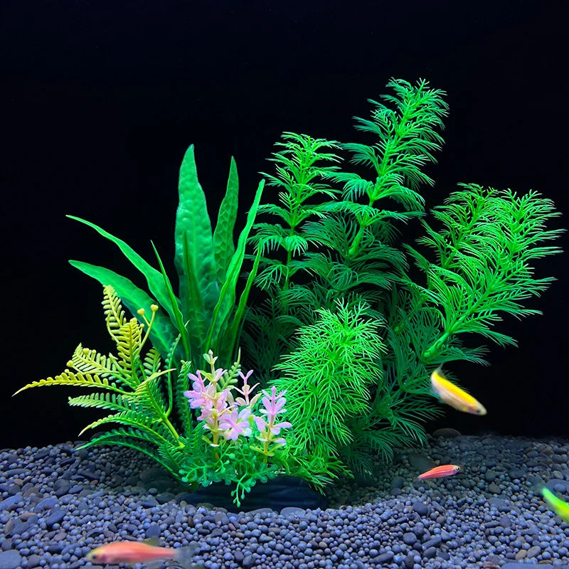 Plantes décoratives aquatiques artificielles avec feuillage vert et fleurs roses sur fond sombre.
