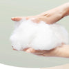 A hand is holding a fluffy white pet tent bed for cats and small dogs.