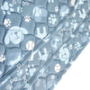 A close-up of a light blue reusable dog pee pad featuring a repeating paw print pattern.