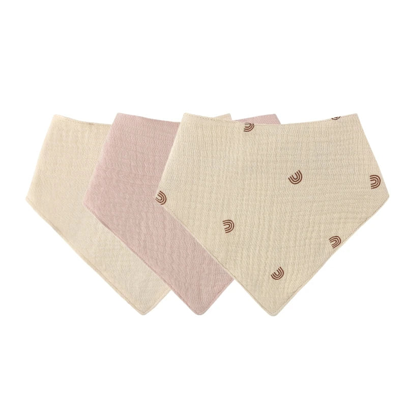 A pack of three light pink and cream soft cotton baby bibs with adjustable snap closures.