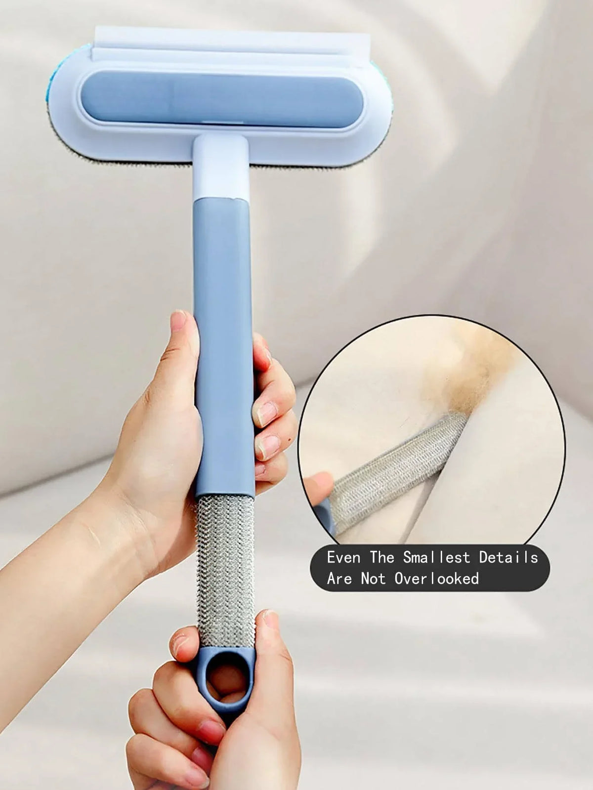 A hand holds a light blue reusable double-sided pet hair removal glove, showing the texture and detail of the product.