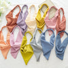Colección de diademas y pañuelos para el cabello de varios colores: rosa, amarillo, naranja y azul.
