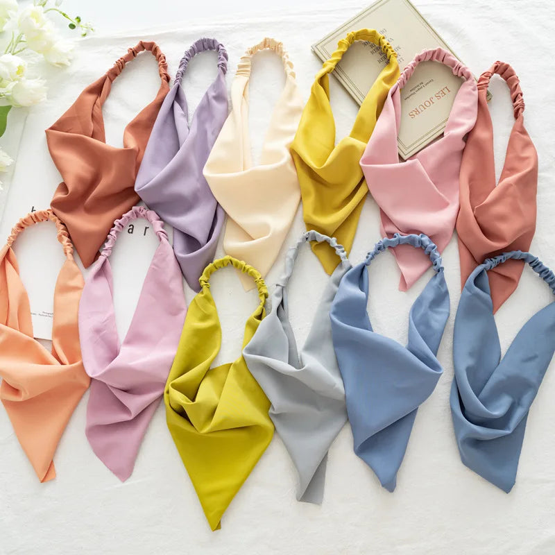 Colección de diademas y pañuelos para el cabello de varios colores: rosa, amarillo, naranja y azul.