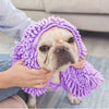 A light-colored dog is being gently wrapped in a purple ultra-absorbent chenille pet bath towel.