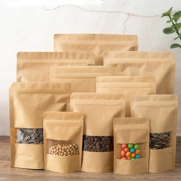 Una pila de bolsas resellables de papel kraft llenas de alimentos secos y hojas de té.
