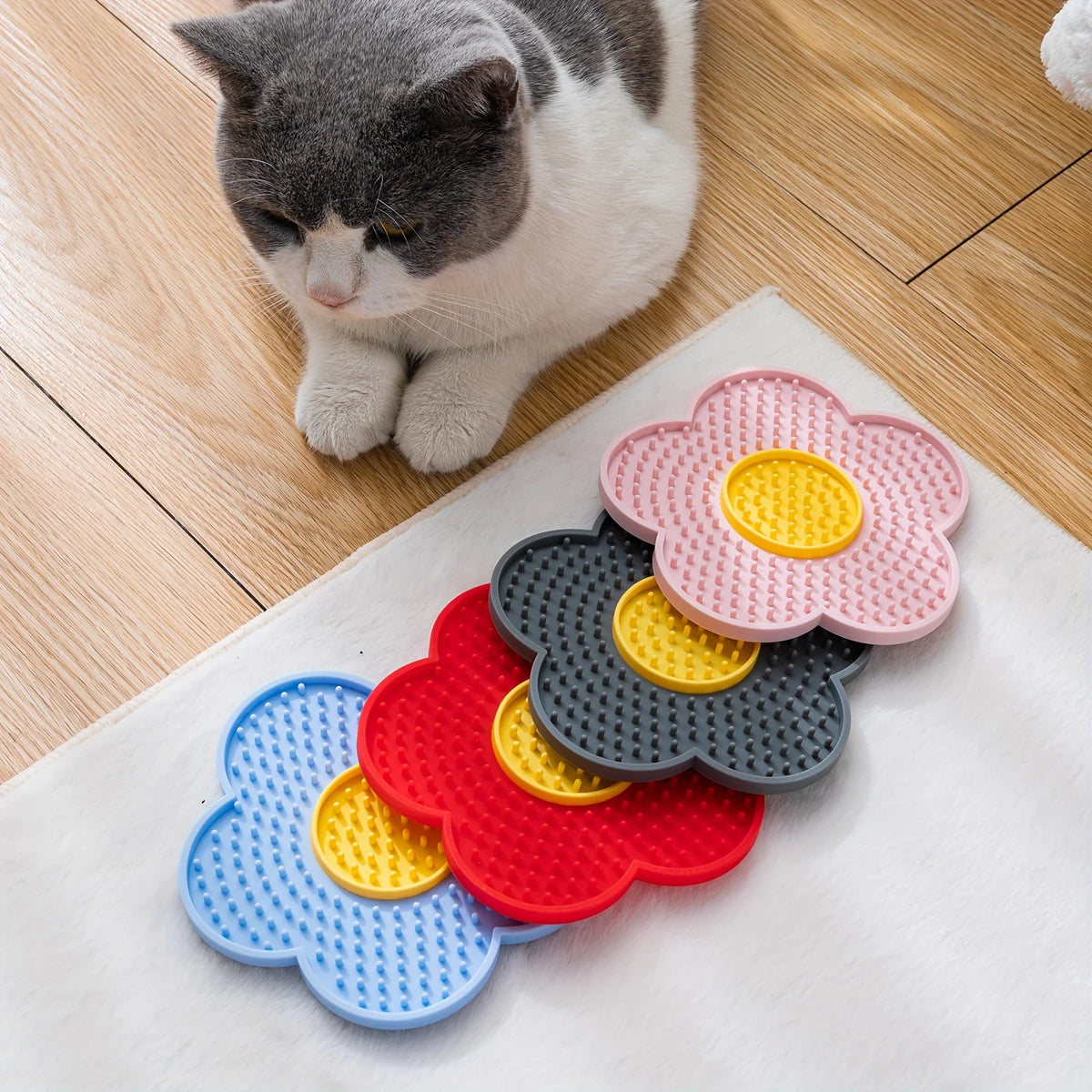 A silicone lick mat with multiple colored silicone discs for dogs and cats placed on a white cloth.