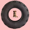 A dark gray rubber chew toy with a circular hole, featuring a small dog sitting inside.