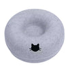 A round, gray felt cat bed with a black silhouette of a cat on the surface.