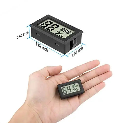 A hand holds a black digital reptile thermometer and humidity gauge displaying 88.8 degrees.