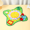A colorful snuffle mat for dogs featuring fabric flowers and puzzle elements on a light yellow surface.