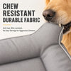 A close-up of a gray durable fabric pet mat being chewed by a golden retriever.
