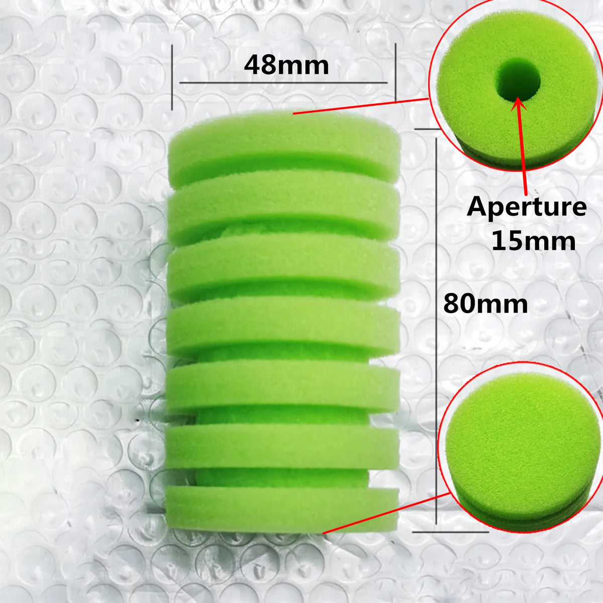 A stack of green biological aquarium sponge filter discs with various aperture sizes and dimensions.