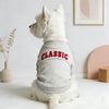 A white dog wearing a gray letter print hoodie with the word CLASSIC on the back.