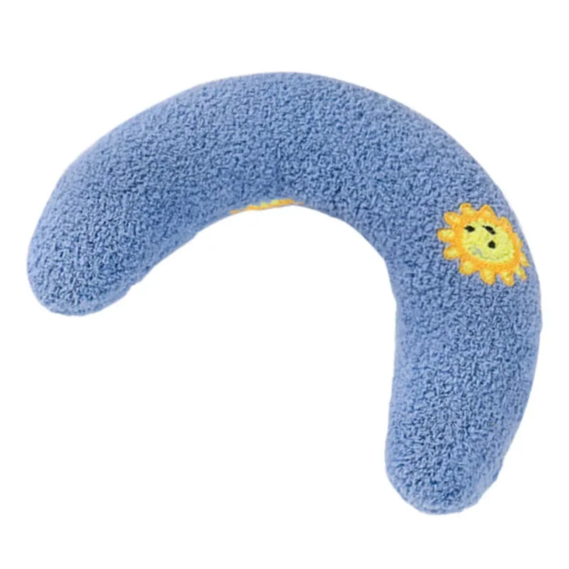 Un coussin d'animal bleu doux et incurvé avec un motif de soleil jaune sur le côté.