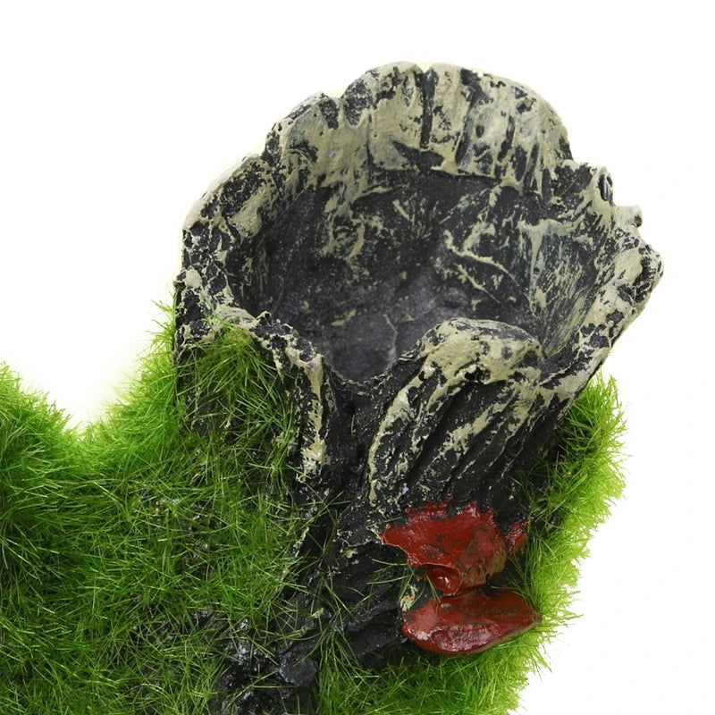 A resin aquarium tree house cave for shrimp and fish is shown emerging from green moss.