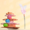 A colorful interactive cat turntable toy with multiple rotating platforms and a pink feather wand.