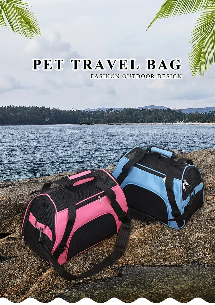 A pink and black pet travel bag is placed on a rock near the ocean with lush green foliage in the background.