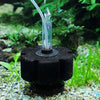 Un filtre biologique en éponge noire avec de l'eau qui coule dans un tube transparent dans un aquarium.