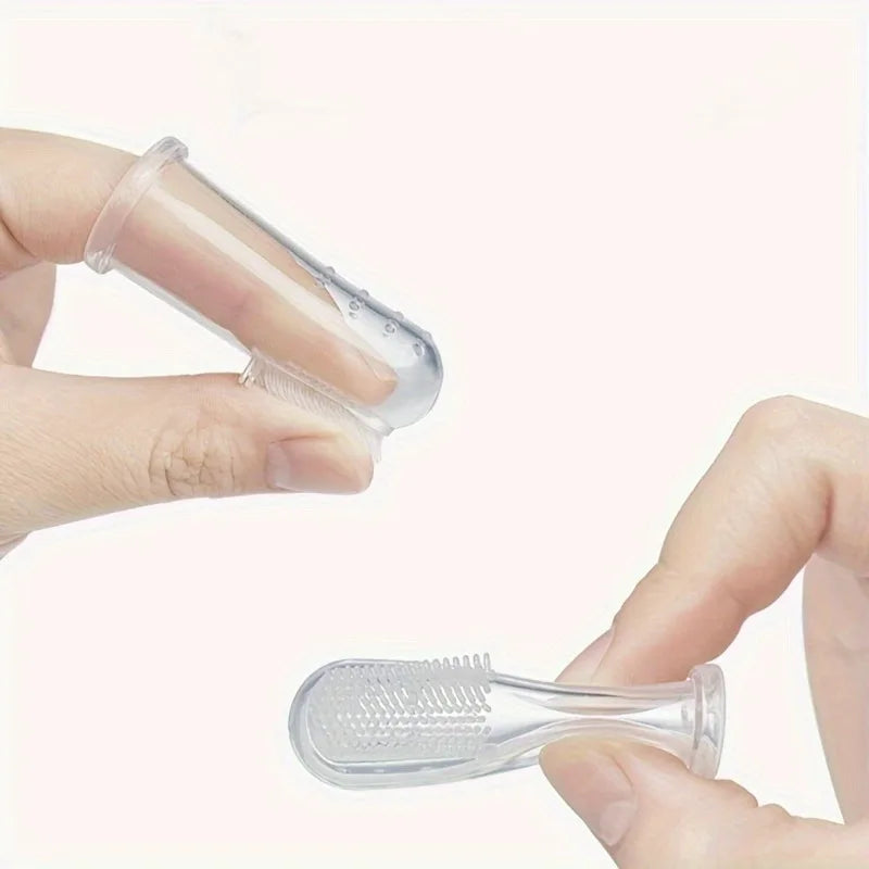 A hand holds a clear silicone pet toothbrush, showing the brush head and handle.