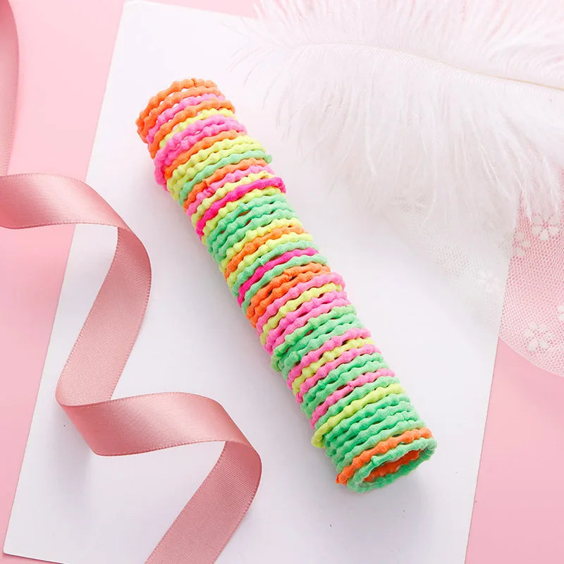 A vibrant, multicolored elastic hair band featuring stripes of orange, pink, and green, displayed on a white background.