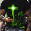 A man wearing a black t-shirt with a glowing green cross design, holding a smartphone.