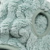 Close-up of a light mint green fuzzy fleece dog sweater with a circular opening detail.