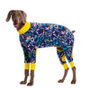 A brown dog wearing a long-sleeved, full-body cartoon print cotton pajama suit featuring various colorful patterns.