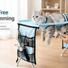 A cat is resting in a blue pet grooming hammock designed for stress-free nail trimming.