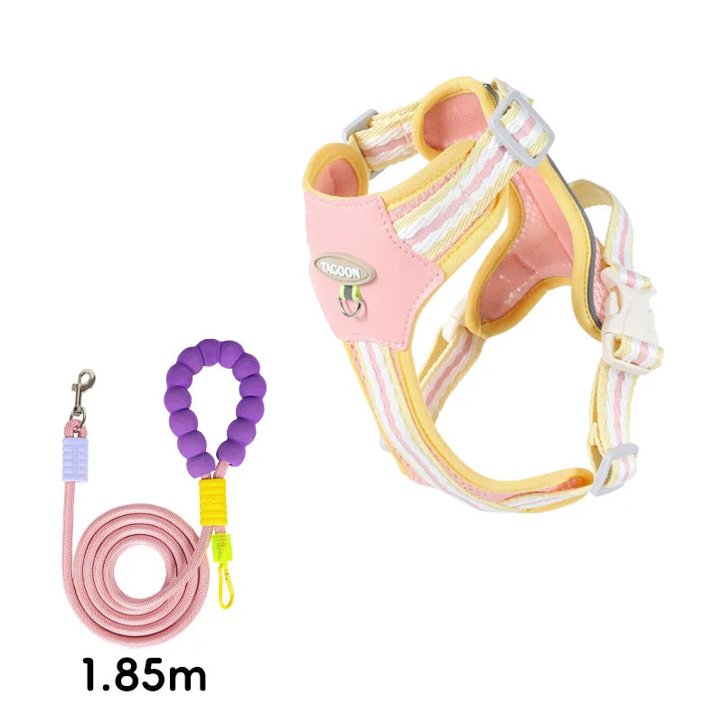 A pink and yellow adjustable no-pull dog harness with reflective straps is shown against a white background.