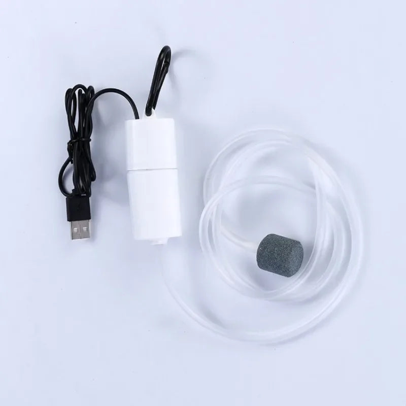 A white portable USB aquarium air pump with a black cord and a clear silicone tube.