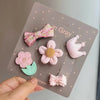 Una tarjeta gris muestra un paquete de cinco lazos de moda rosas y verde claro para clips de pelo de perros y gatos.